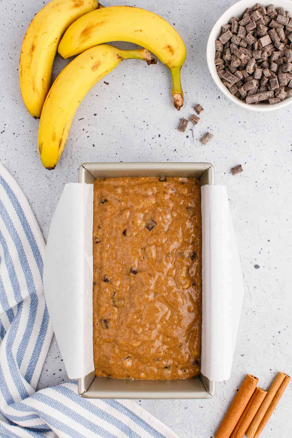 adding the banana bread batter into the loaf pan.