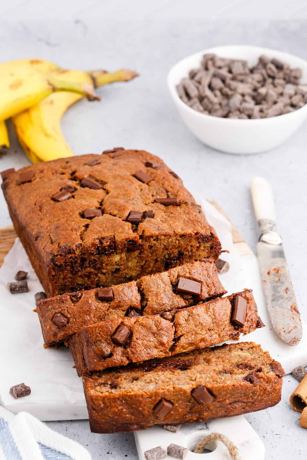 chocolate chip banana bread sliced with a bread knife to the side.