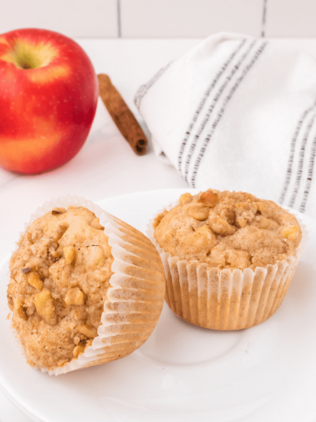 two apple crumble muffins on a white plate.