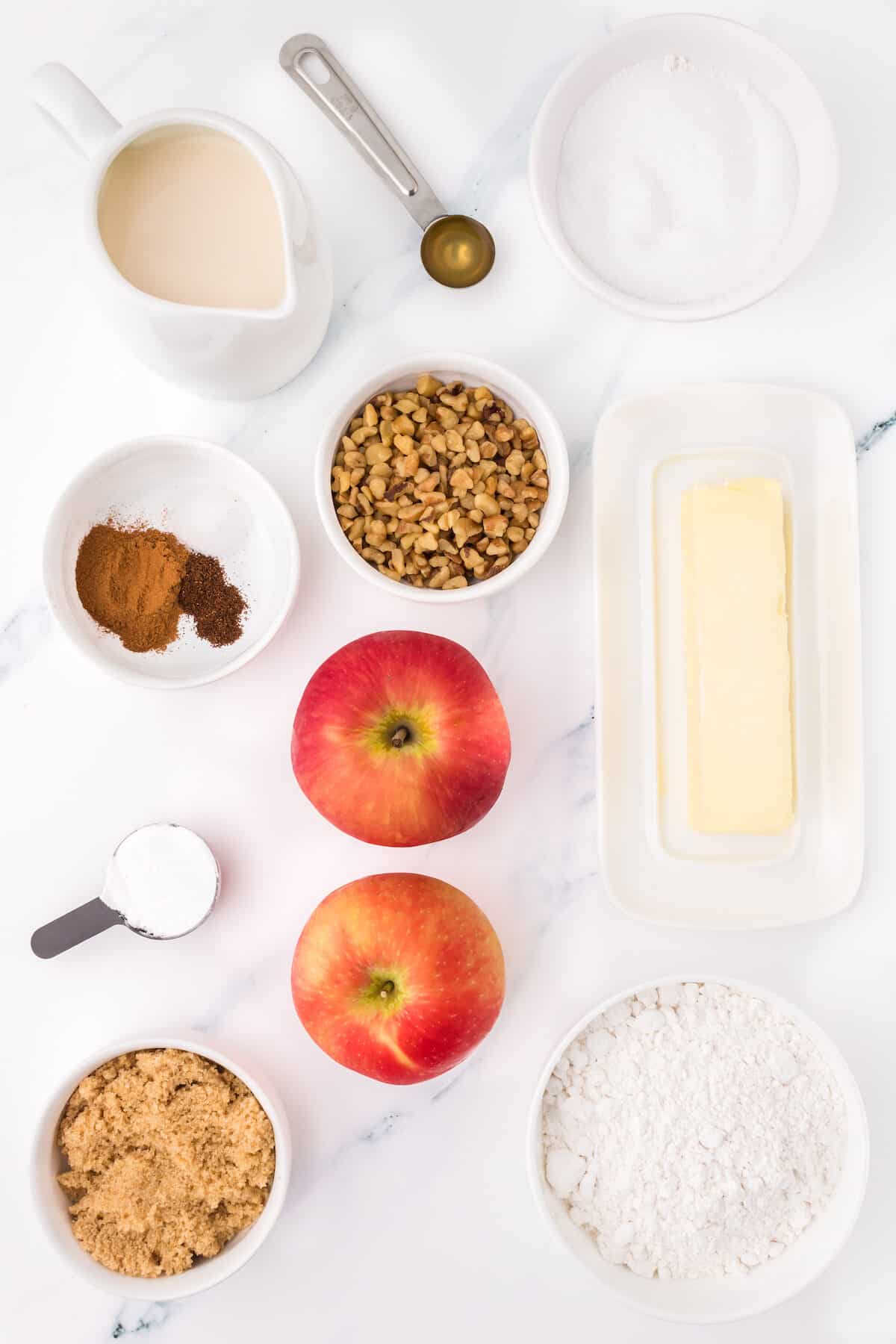apple muffin ingredients in little bowls and measuring spoons.