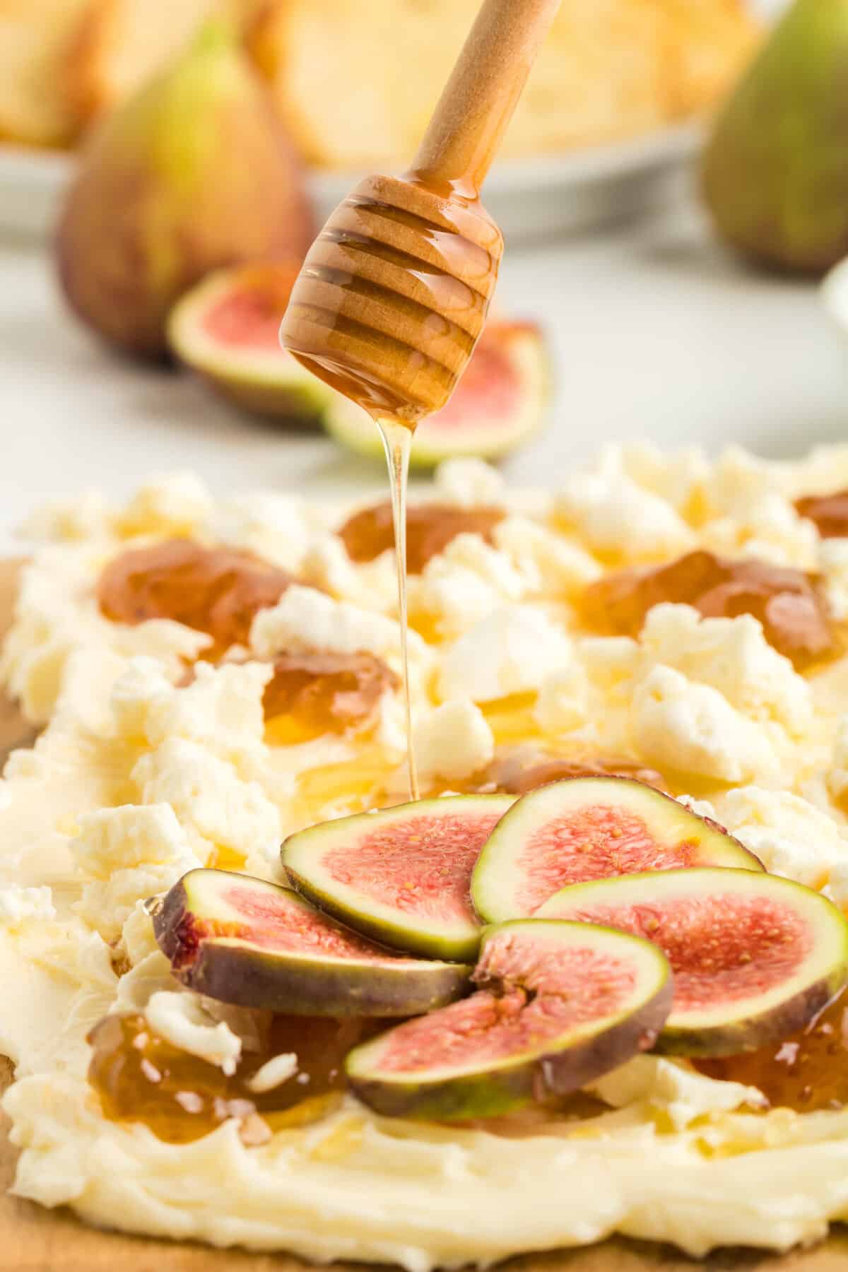 drizzling honey over the top of the fig and goat cheese butter board.
