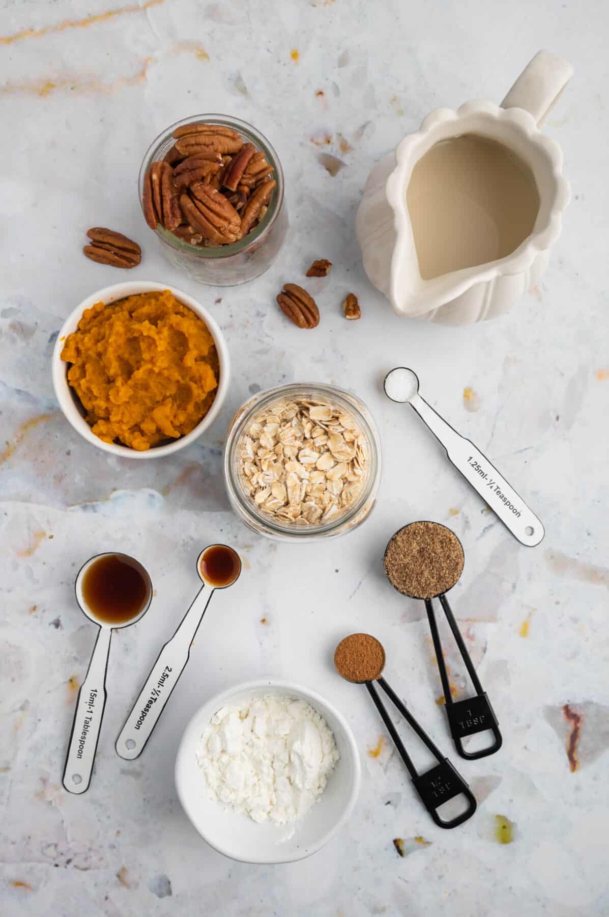 pumpkin overnight oats ingredients in small bowls and measuring cups.