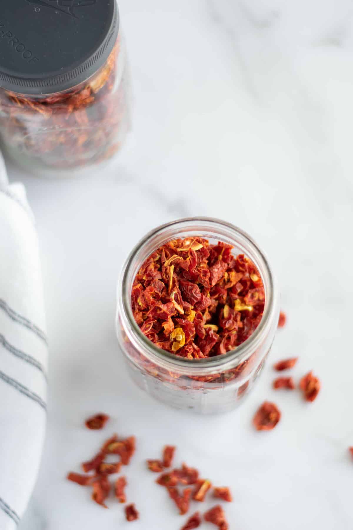 mason jars of dehydrated tomatoes on tabletop.