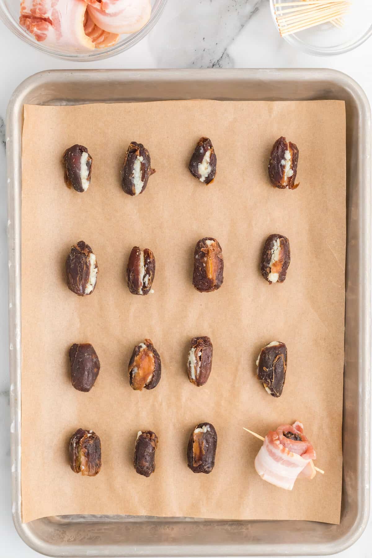 lining the baking sheet with cheese stuffed dates.