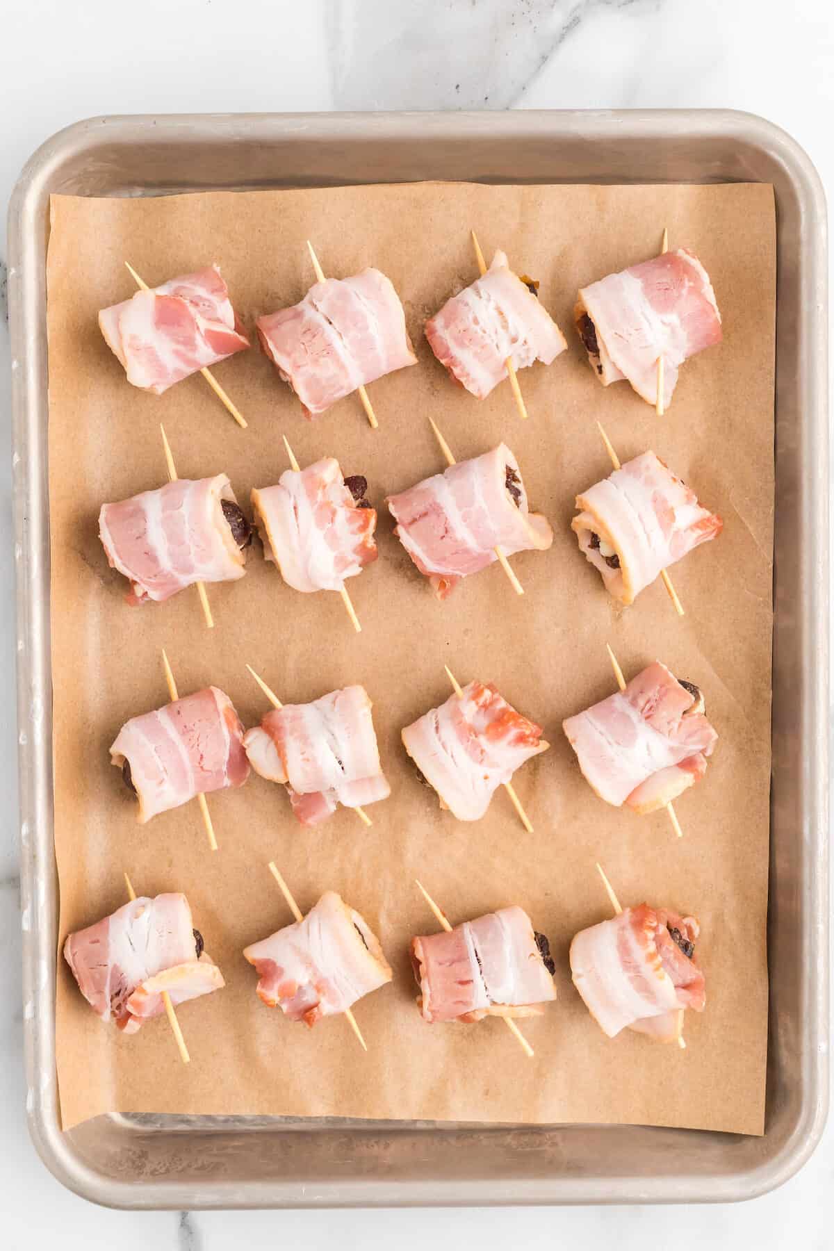 wrapping the cheese stuffed dates with bacon slices and securing with a toothpick.