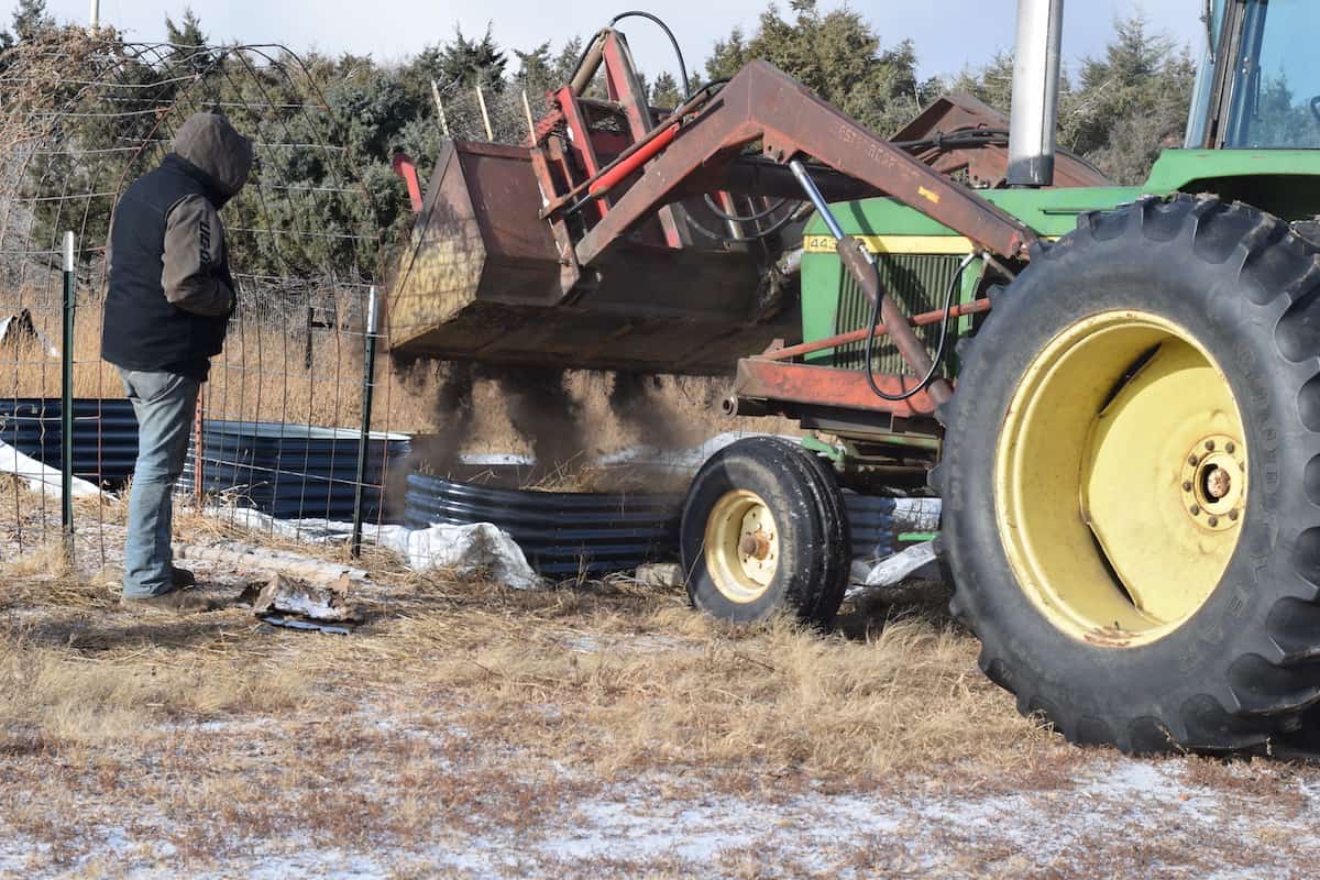 using a tractor to add garden soil to the raised beds. 