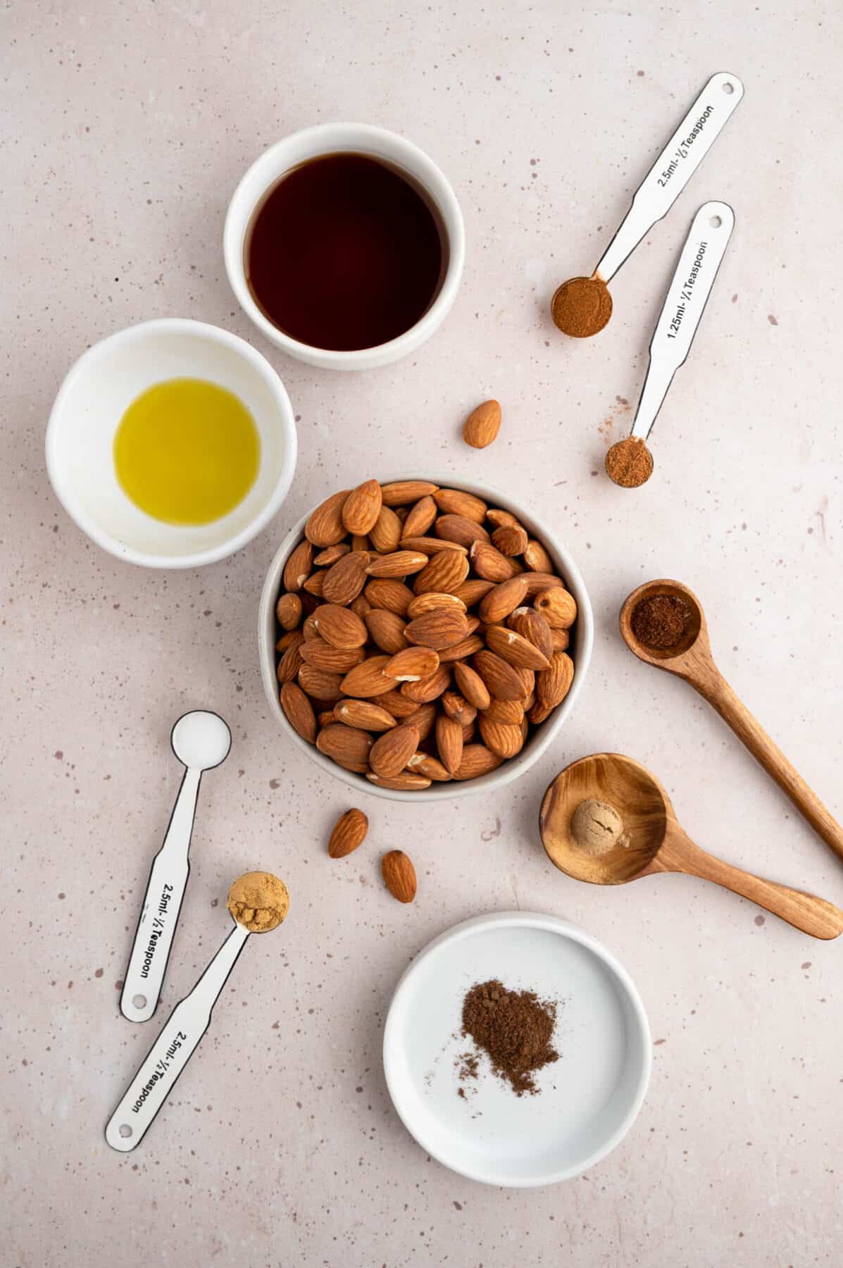 ingredients for the spiced almonds recipe in small bowls and measuring spoons. 