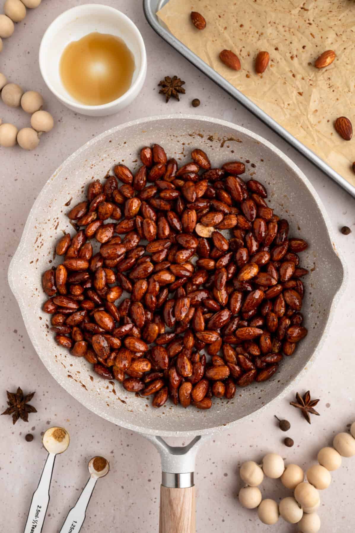 spices and maple syrup over the roasted almonds in a skillet.