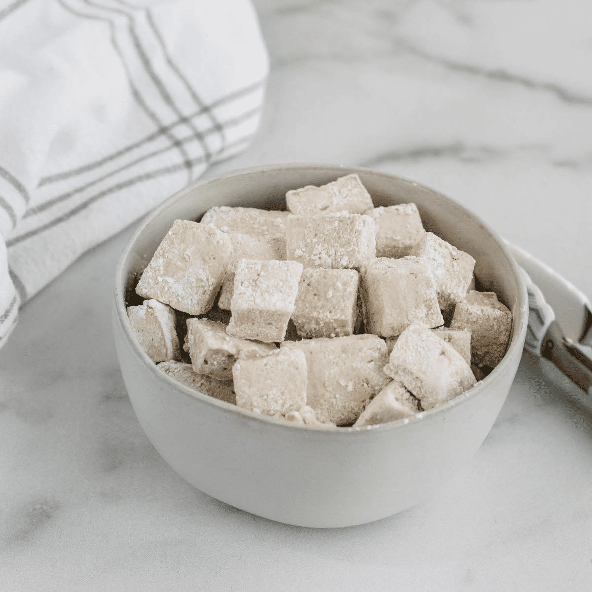 white bowl filled with healthy marshmallows and a white tea towel to the side.