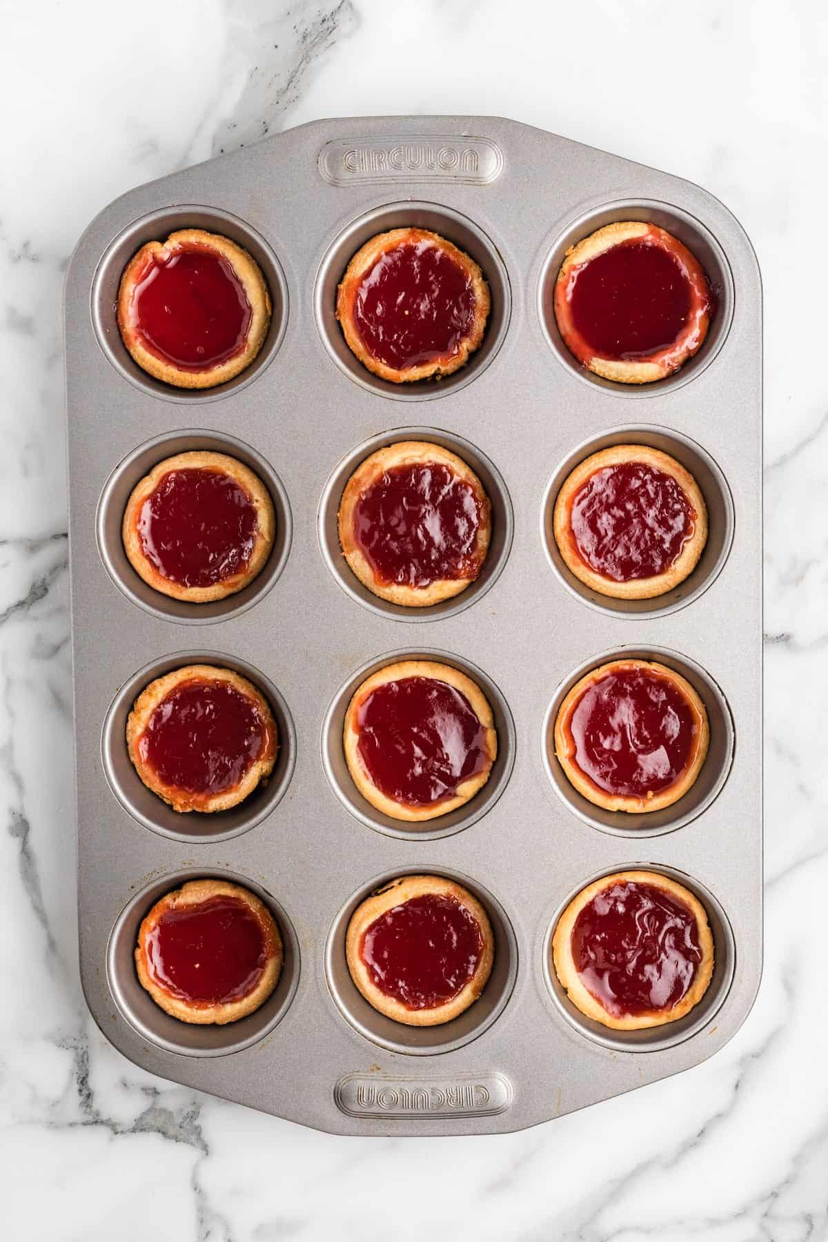 baked jam tarts inside of the muffin tin.
