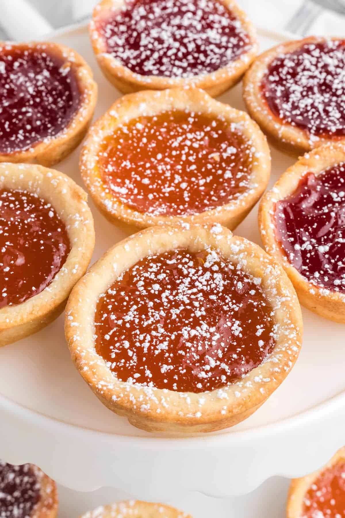 closeup of the mini jam tarts on a white plate.