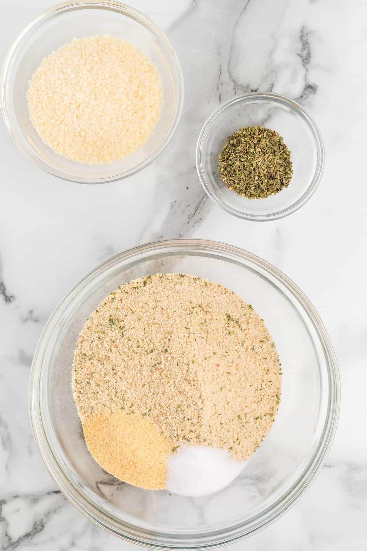 seasonings and breadcrumbs layered together in a glass bowl.