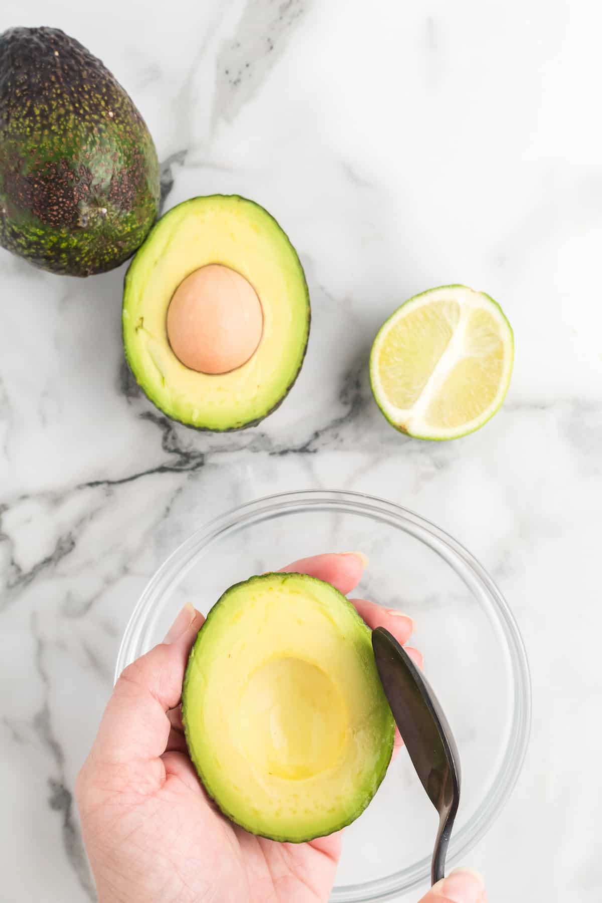 removing the avocado from the skin.