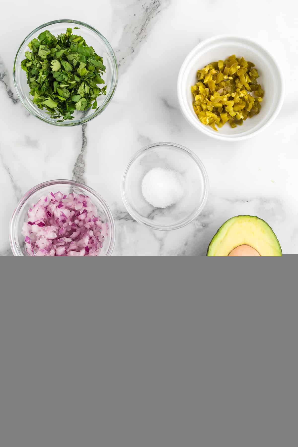 ingredients for the fresh guacamole chopped and in small glass bowls.