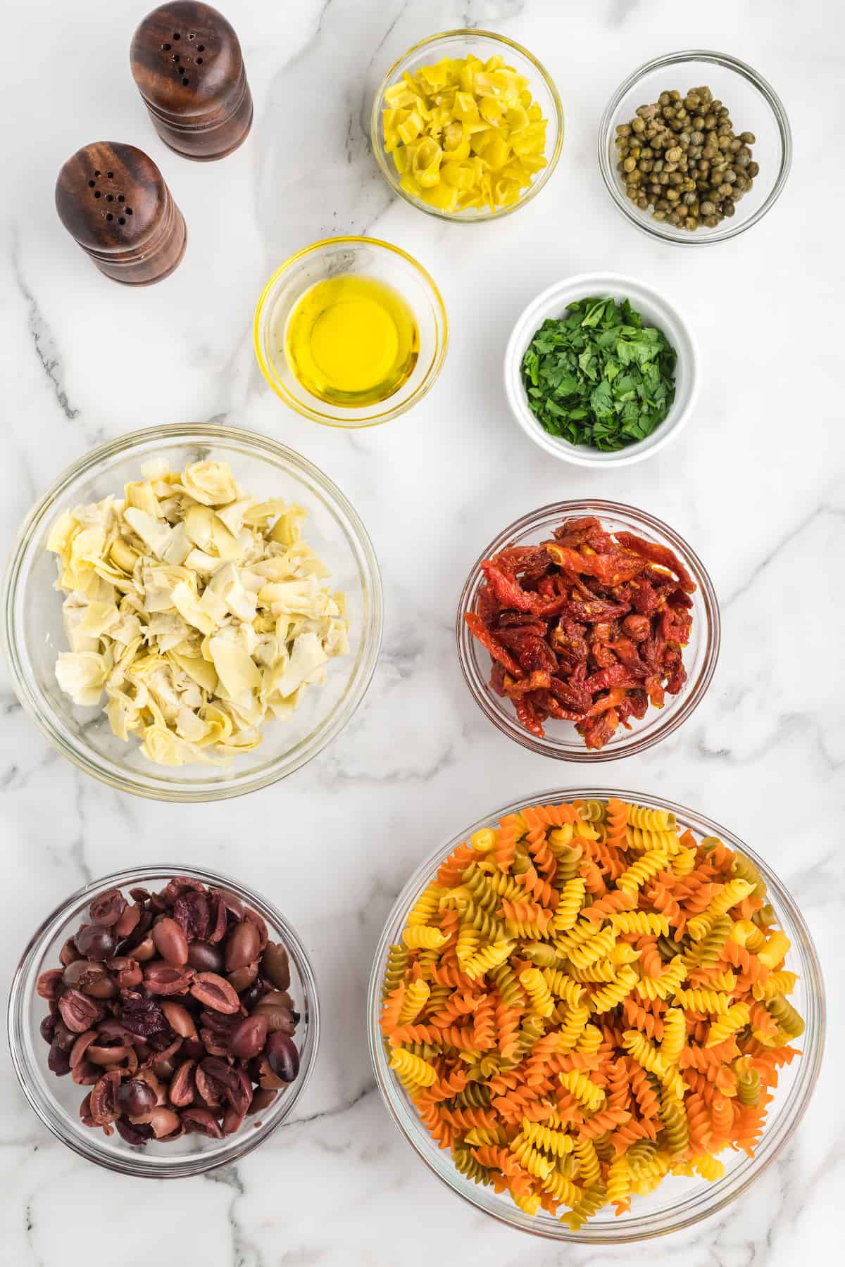 ingredients for the Mediterranean pasta salad in small bowls.