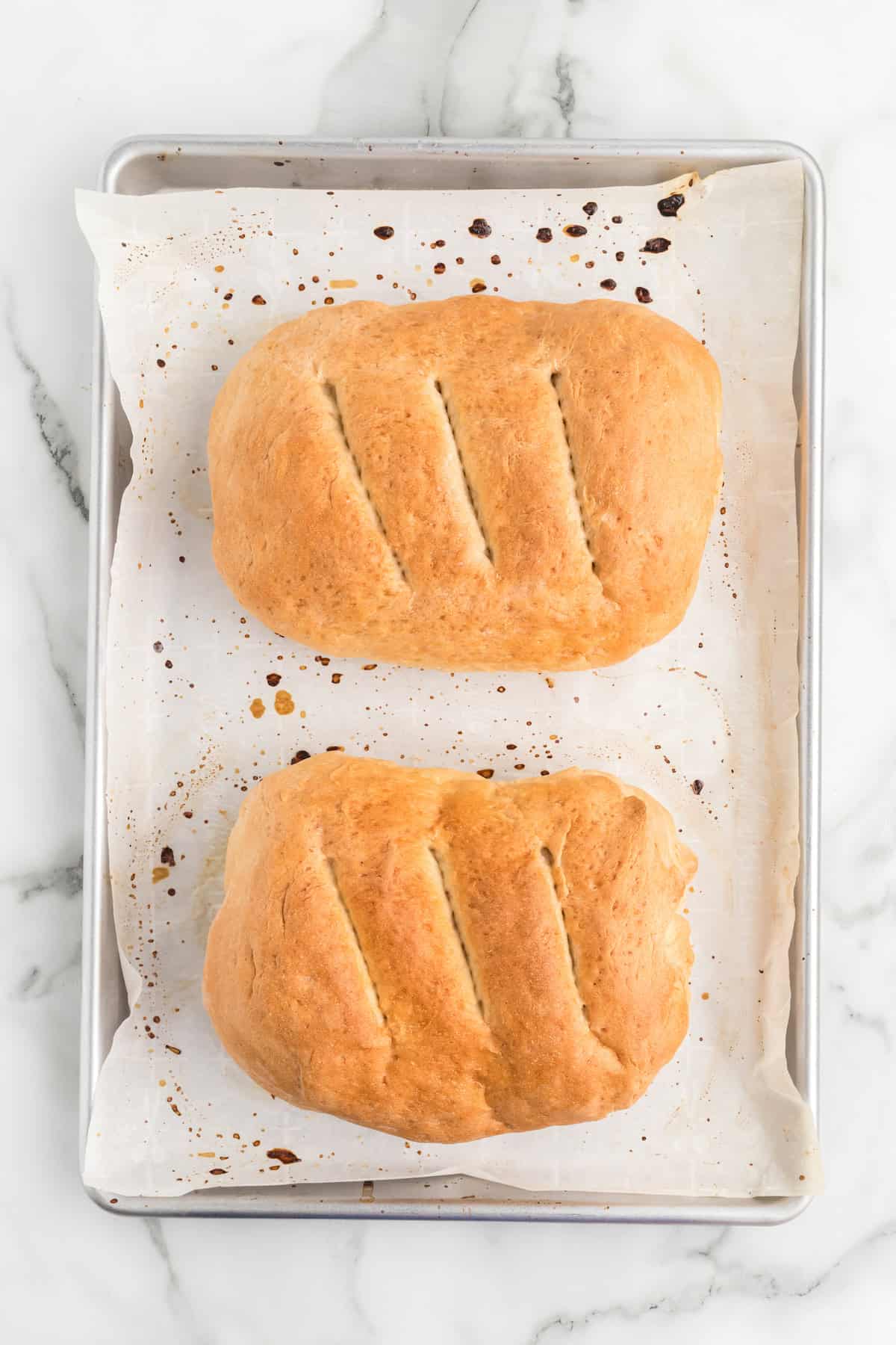 fresh baked bread loaf on a parchment paper lined baking sheet. 