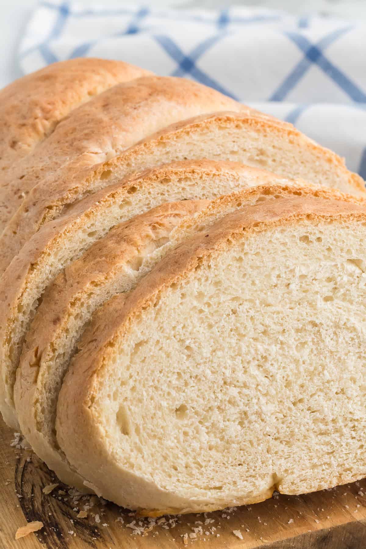 slices of the italian loaf bread on a rustic wooden cutting board.