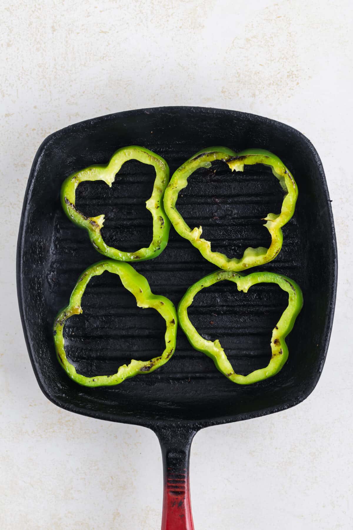 slices of green bell pepper on a grill pan.