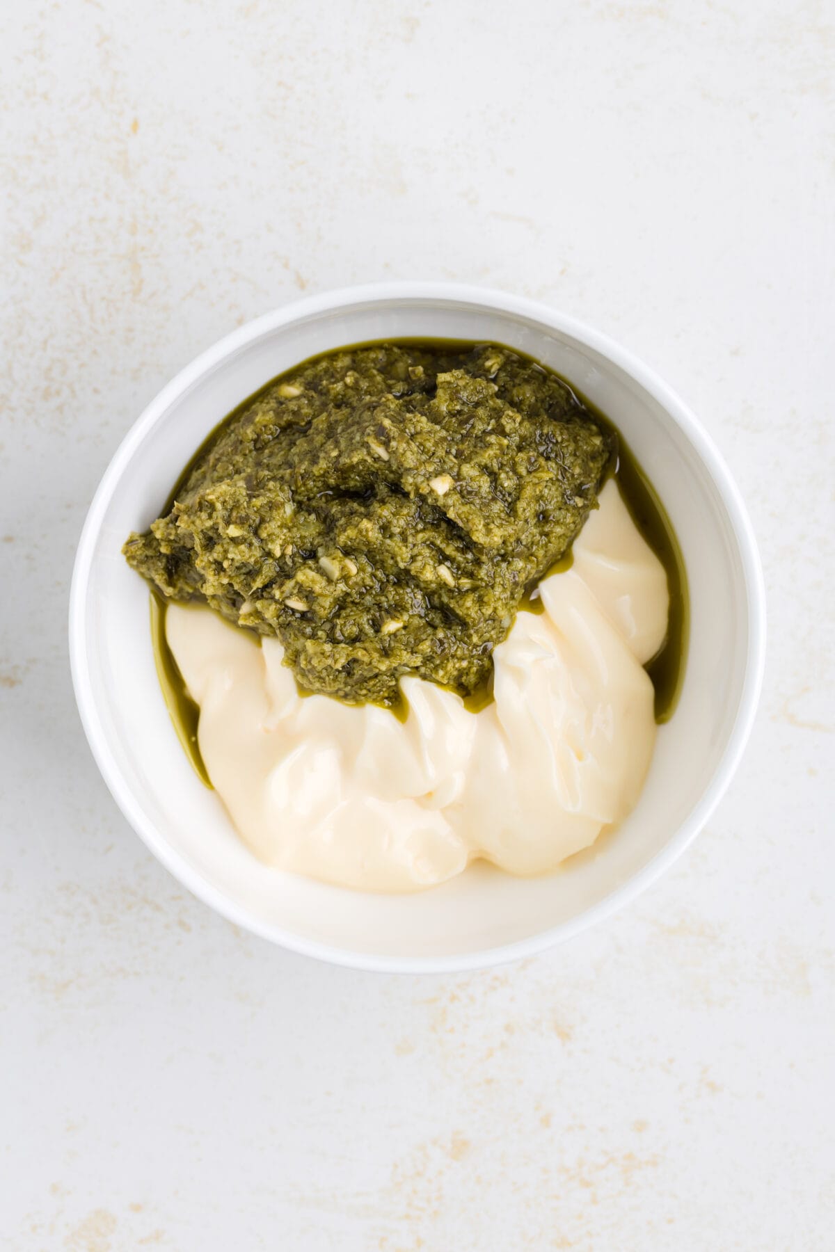 mayo and pesto in a small white bowl. 