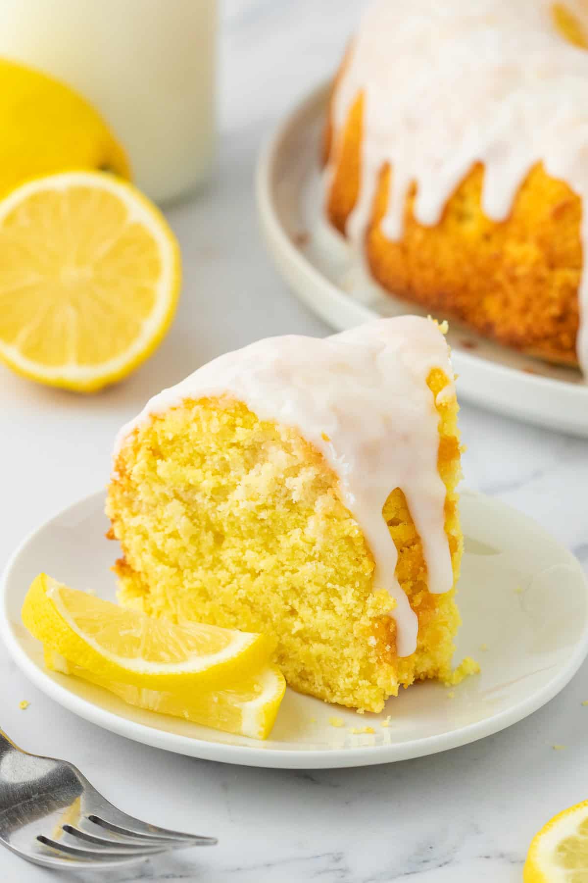 slice of lemon bundt cake on a small white dessert plate. 