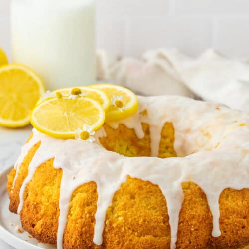 lemon bundt cake with glaze over top and on a white plate.