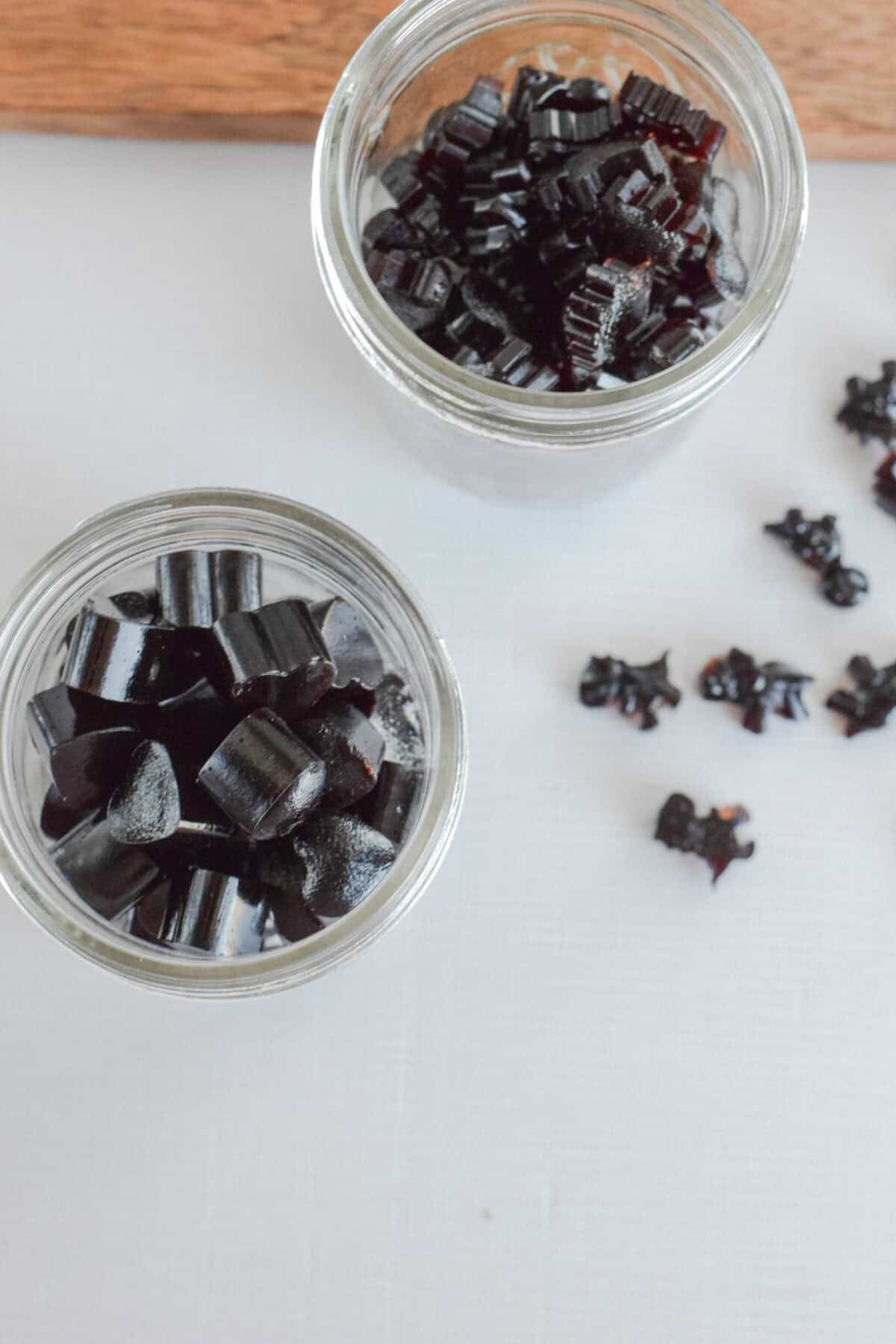 two small mason jars with finished elderberry gummies on a table. 