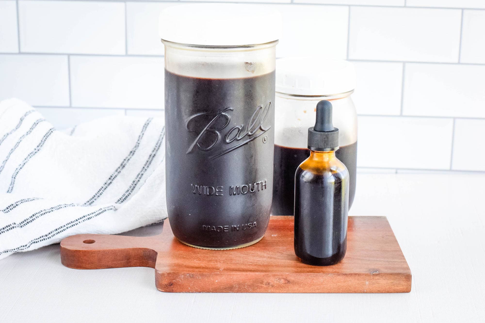 finished elderberry syrup in mason jars and dropper bottle.