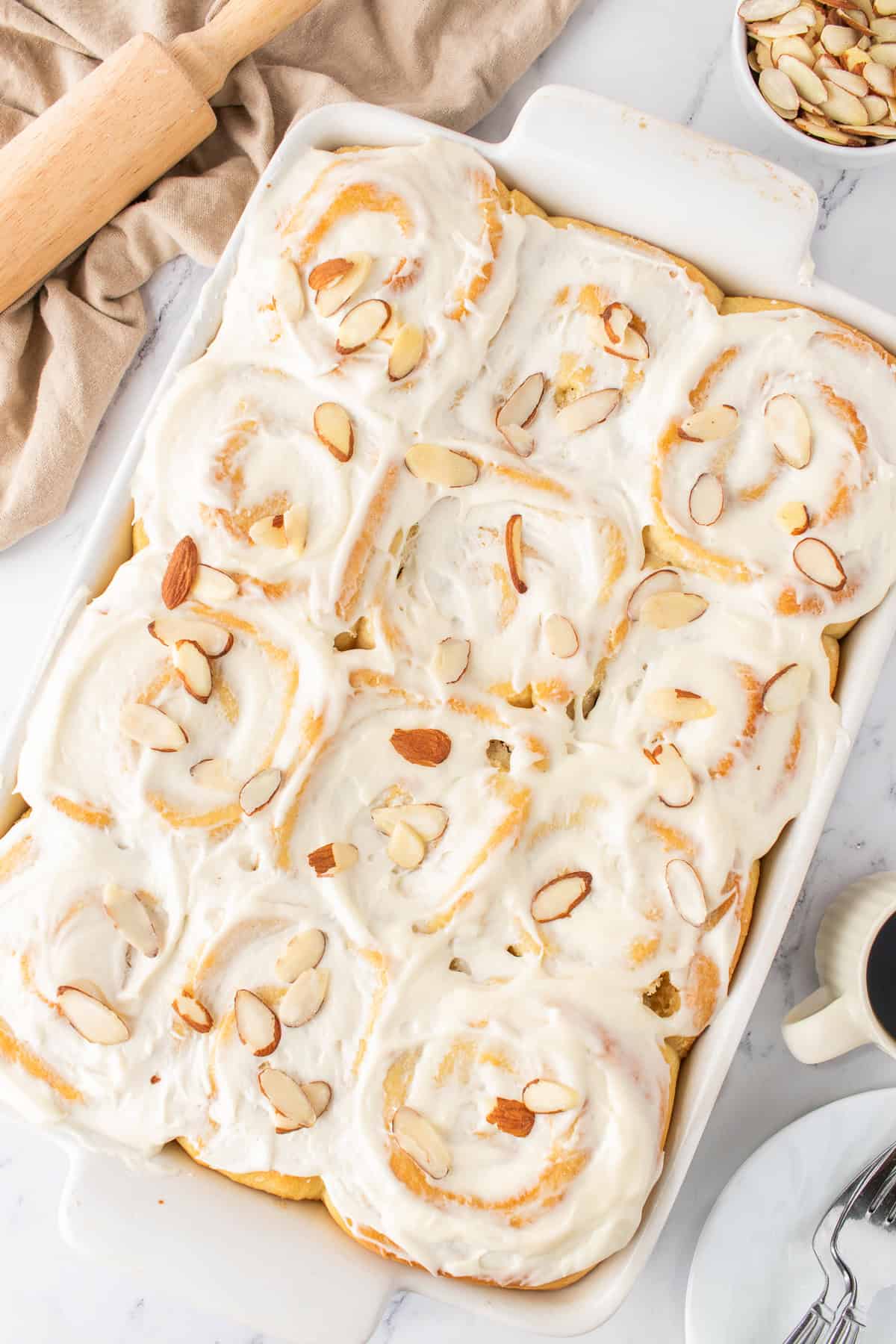 white baking dish with the almond sweet rolls with cream cheese frosting. 