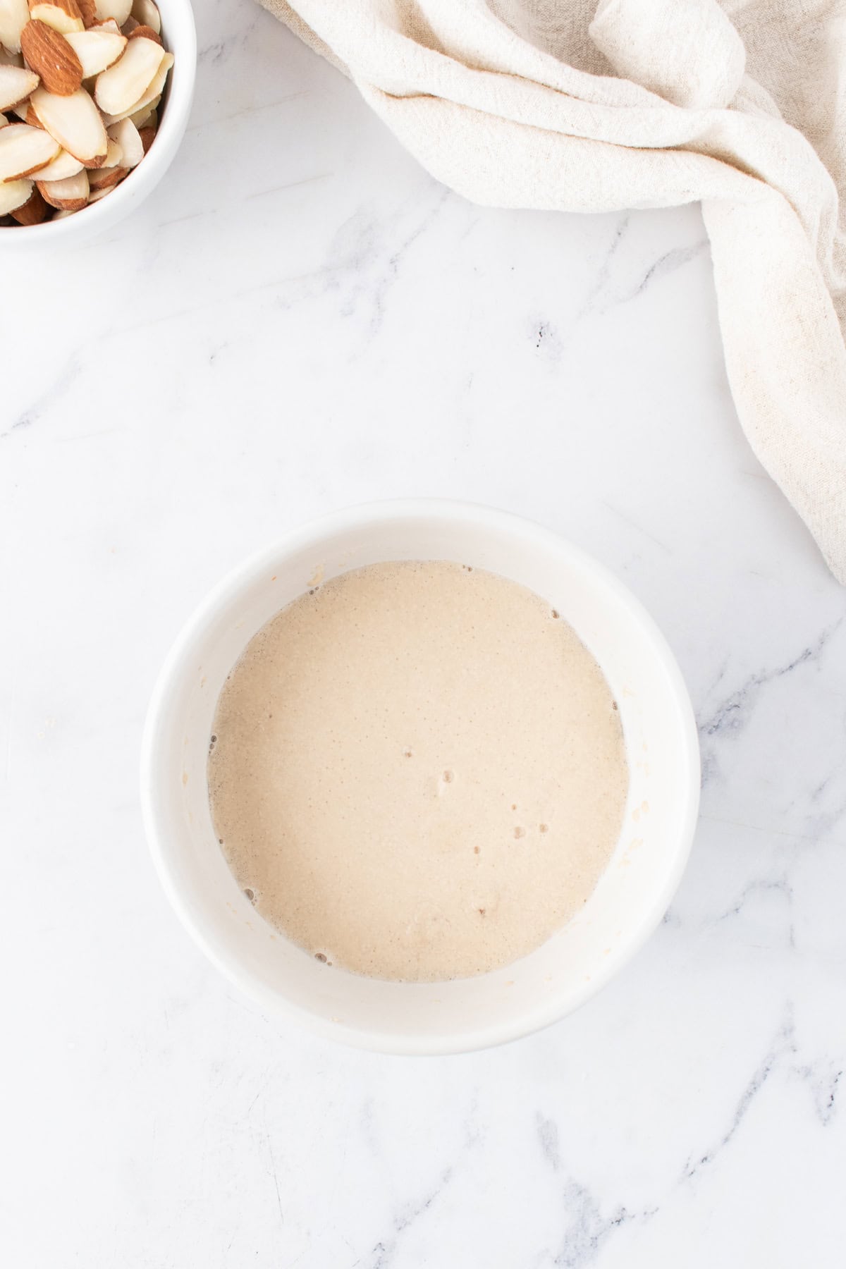 yeast mixture in a small white bowl.