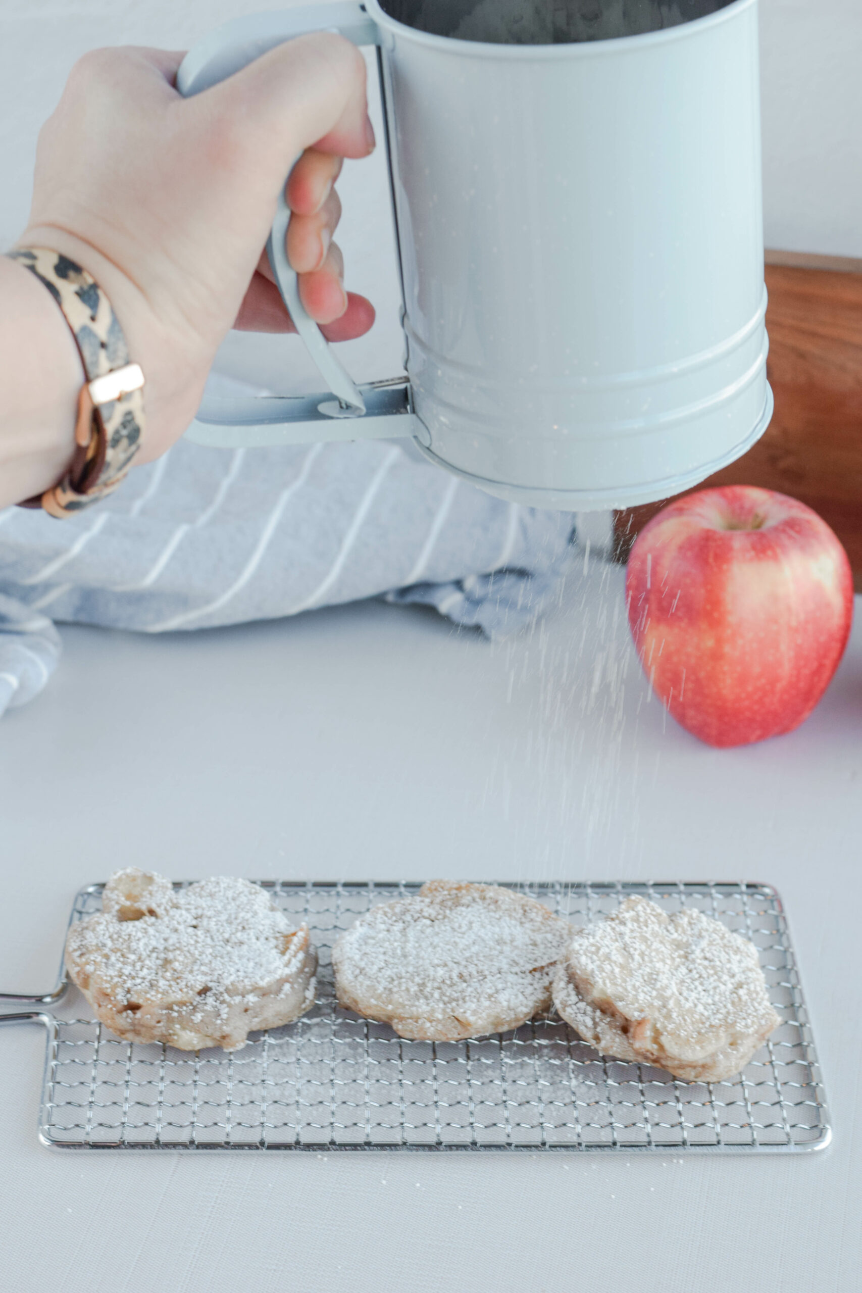 dusting the sourdough fritters with powdered sugar. 