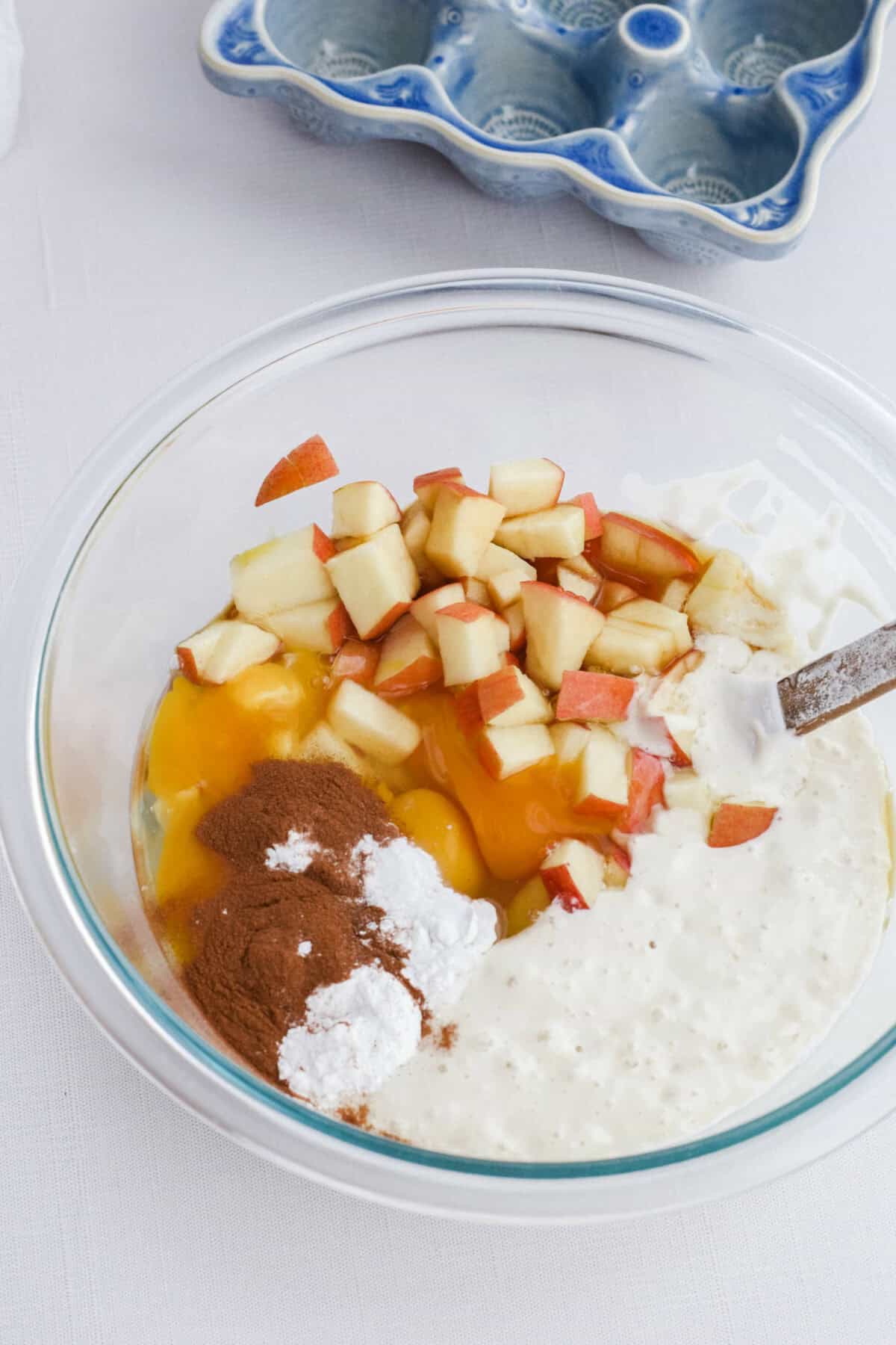 ingredients for the apple cinnamon sourdough pancakes in a mixing bowl. 