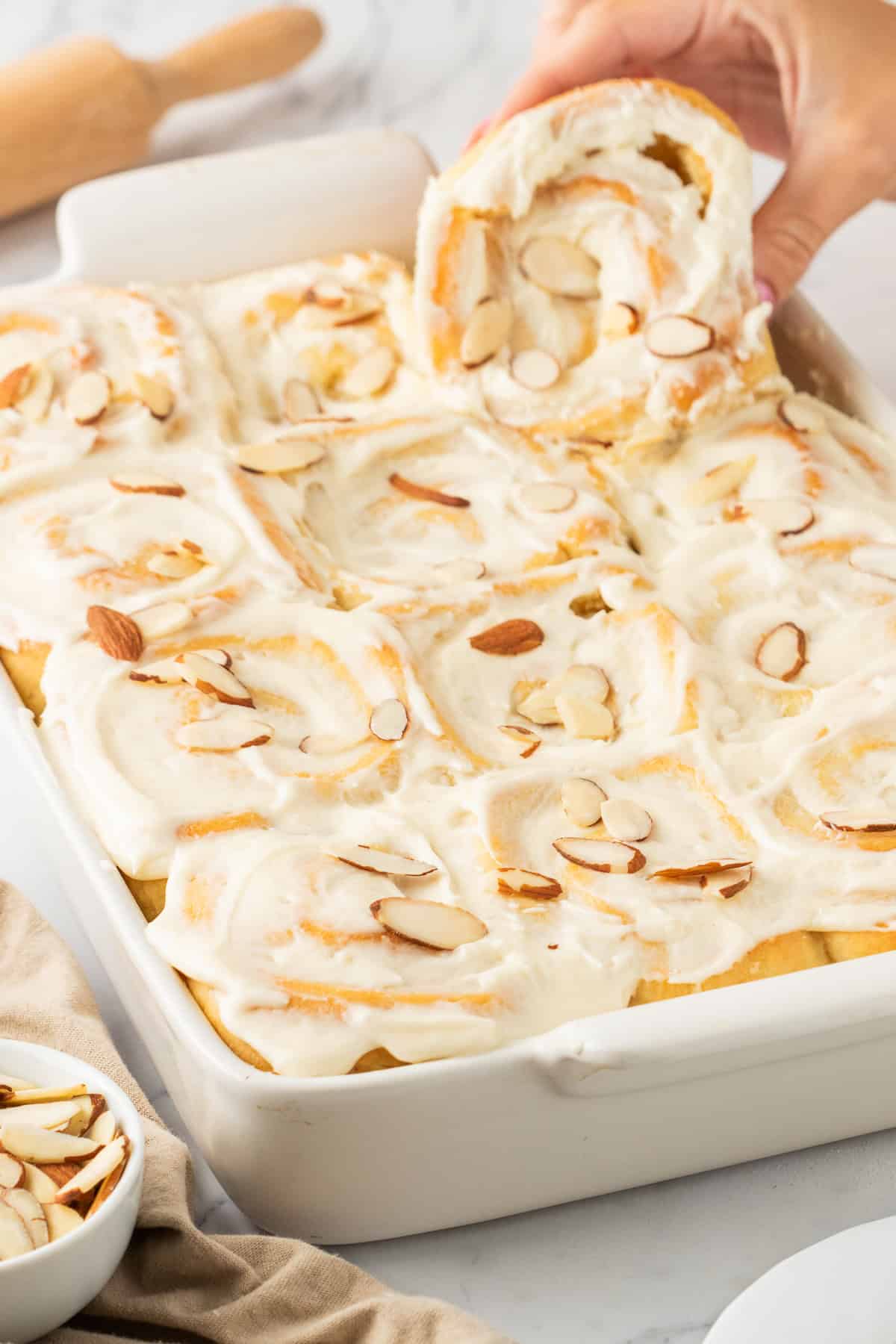 white baking dish with finished almond sweet rolls.