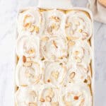 finished almond sweet rolls with cream cheese frosting and almond slices on top.