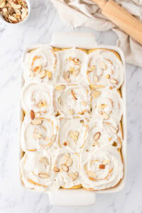 finished almond sweet rolls with cream cheese frosting and almond slices on top.