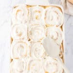 spreading almond flavored cream cheese over the sweet rolls.