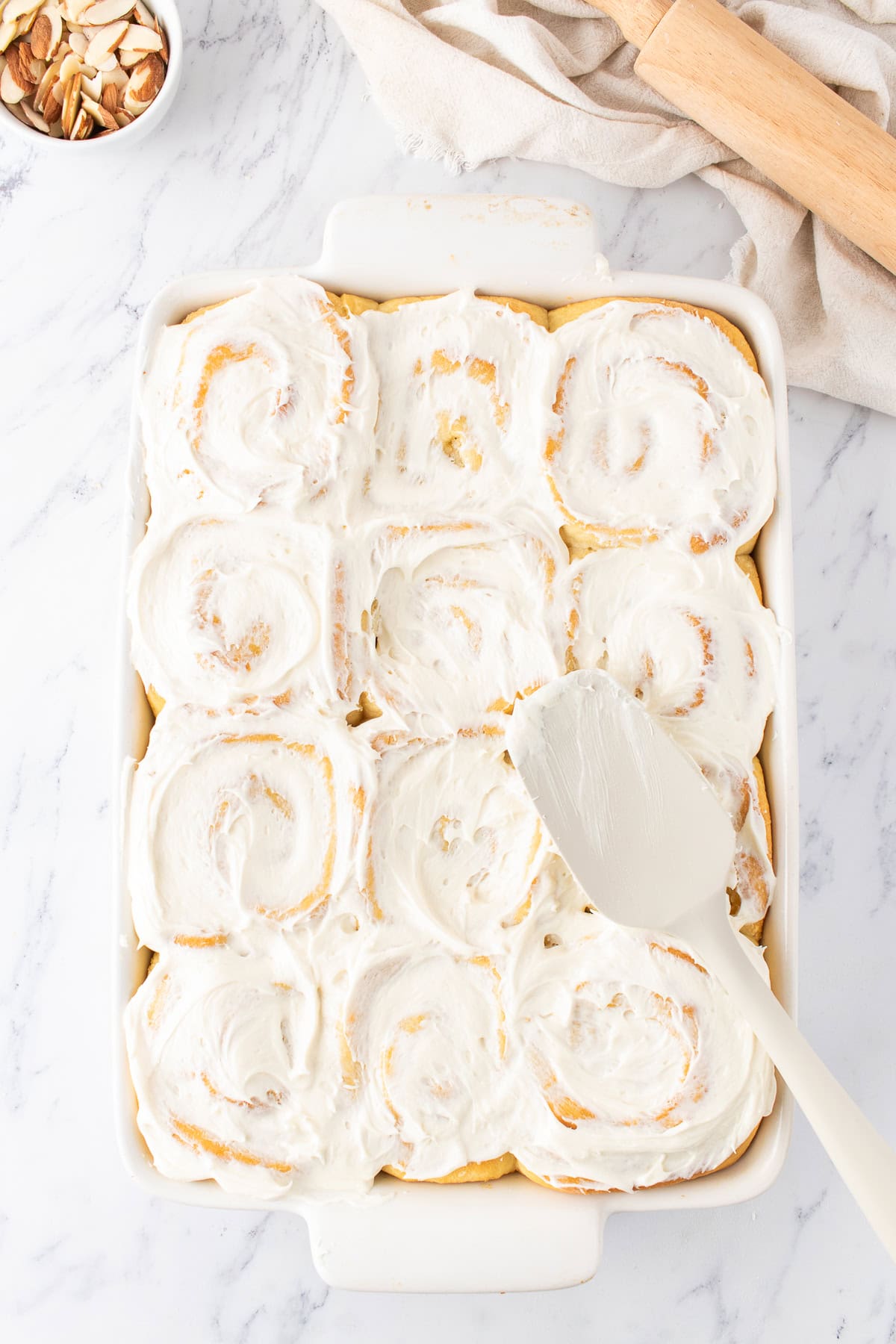 spreading almond flavored cream cheese over the sweet rolls. 