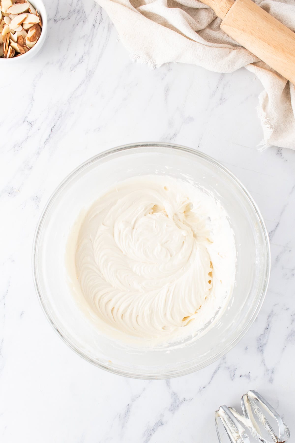 small mixing bowl with cream cheese frosting for the almond sweet rolls. 