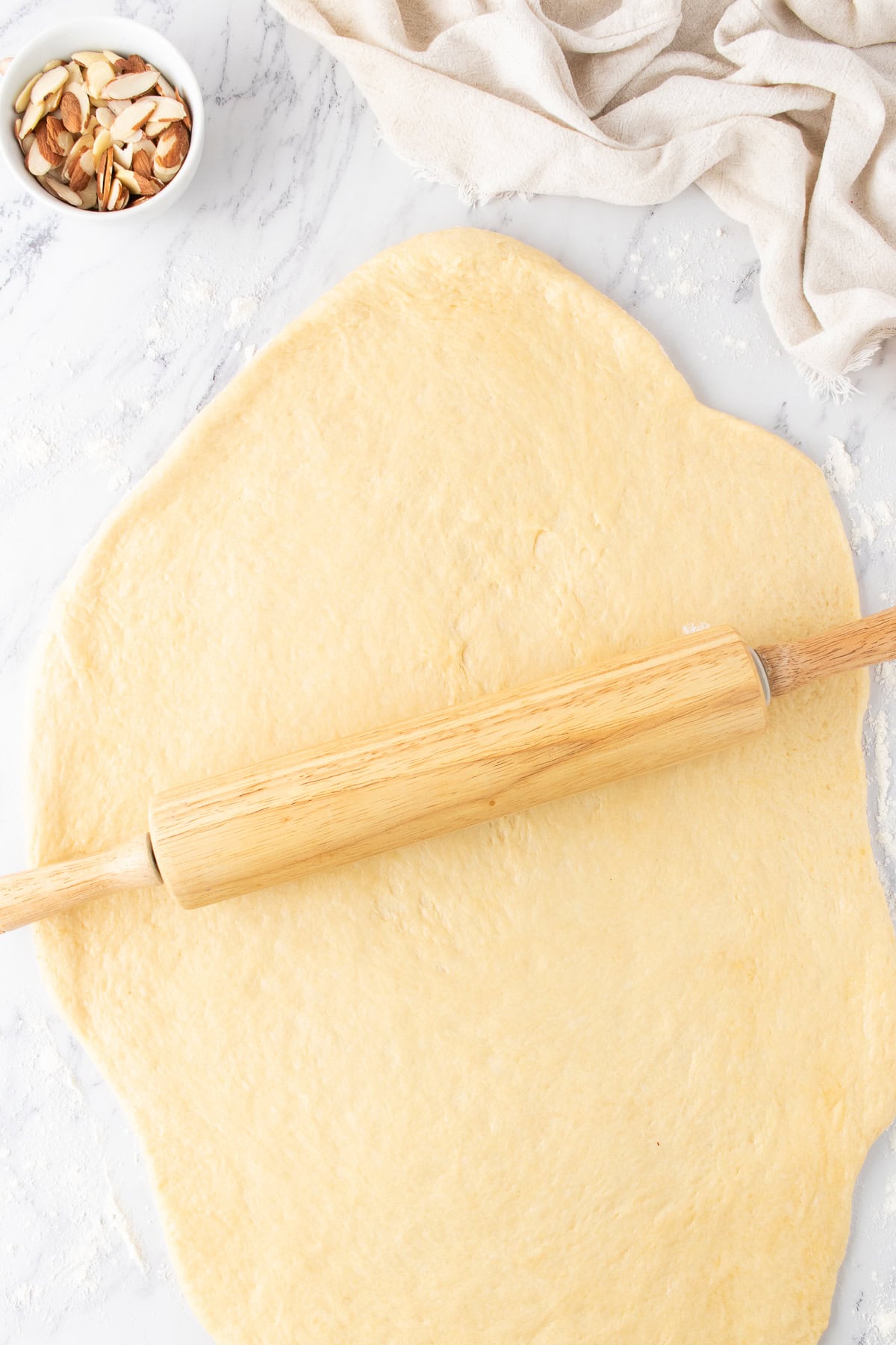 rolling out the sweet dough on a countertop. 