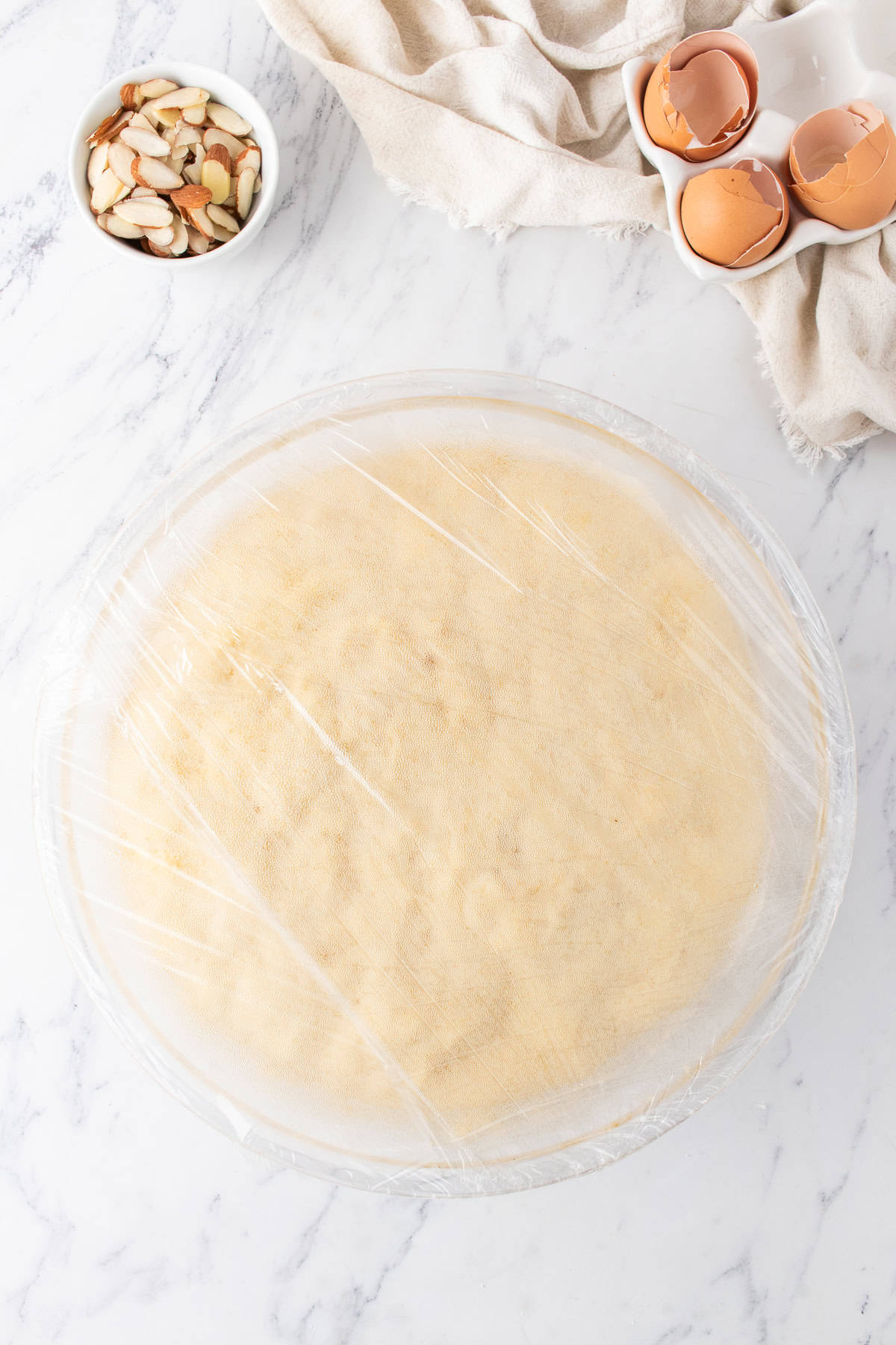 sweet roll dough in a large bowl with plastic wrap over top. 