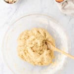 mixing the dough in a large bowl with a wooden spoon.