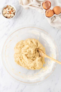 mixing the dough in a large bowl with a wooden spoon.