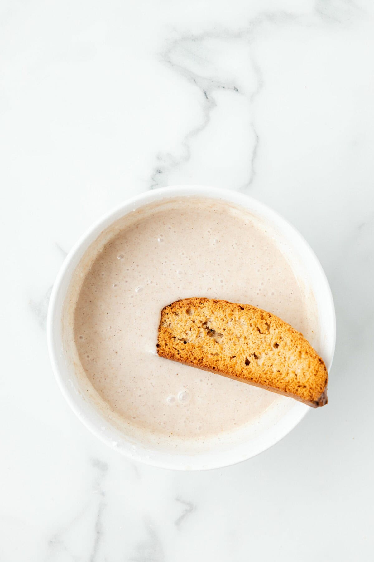 dipping the biscotti in the glaze. 