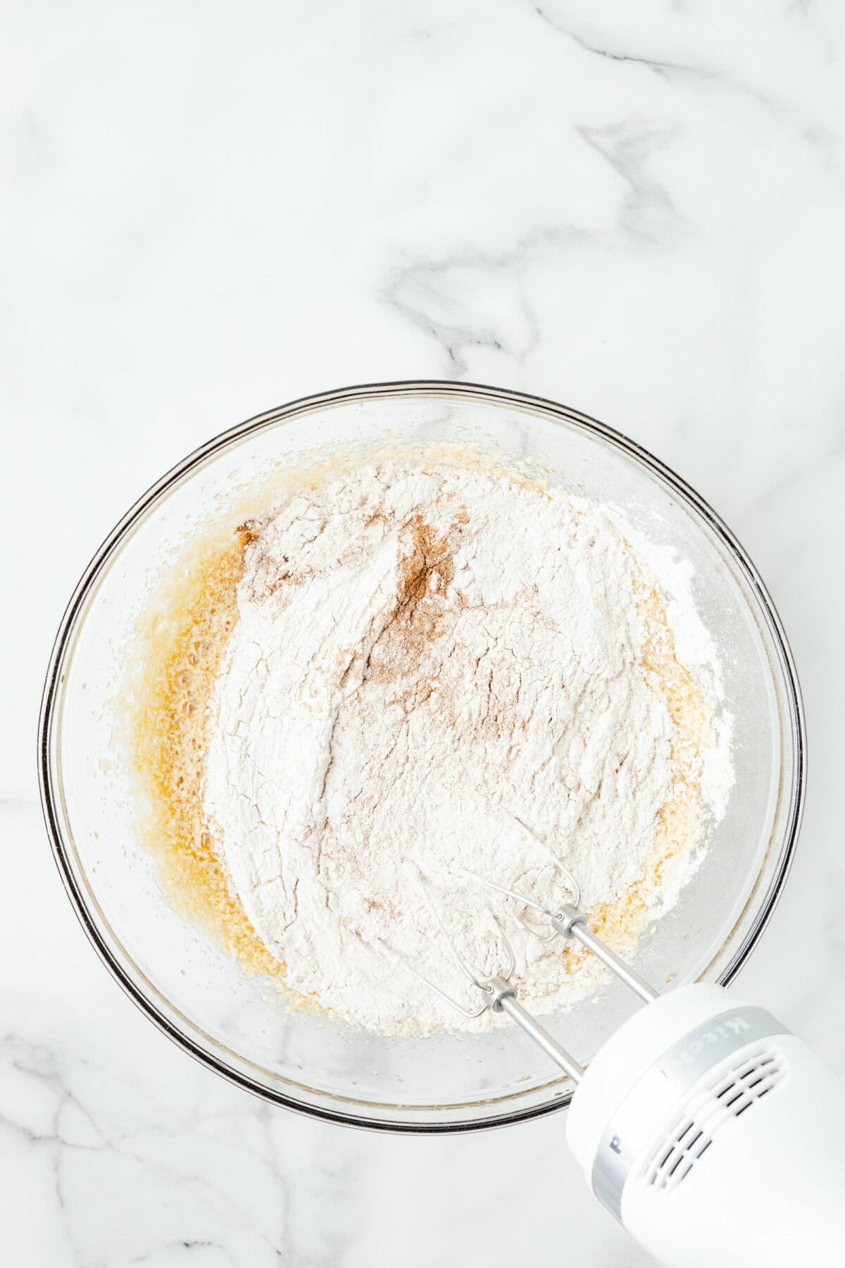 adding the flour to the mixing bowl with the wet ingredients. 