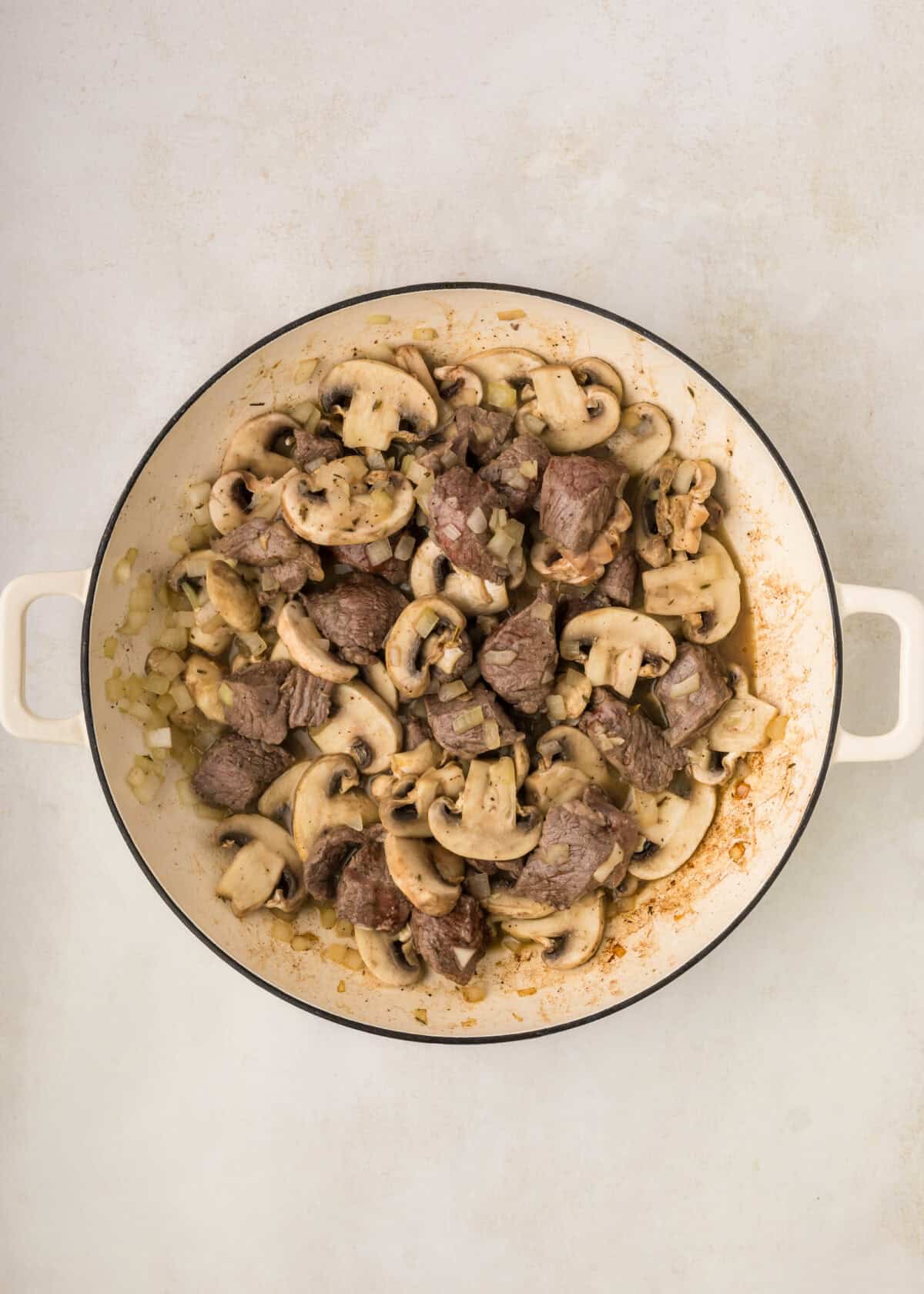 beef with mushrooms in a dutch oven.