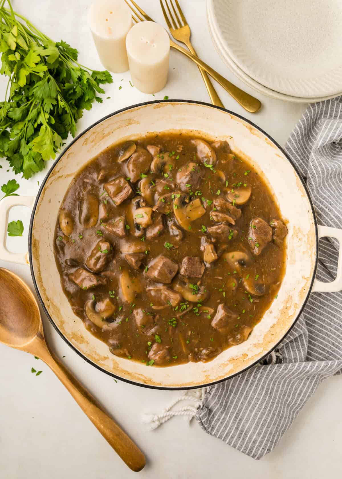 beef tip gravy topped with chopped parsley in a white dutch oven. 