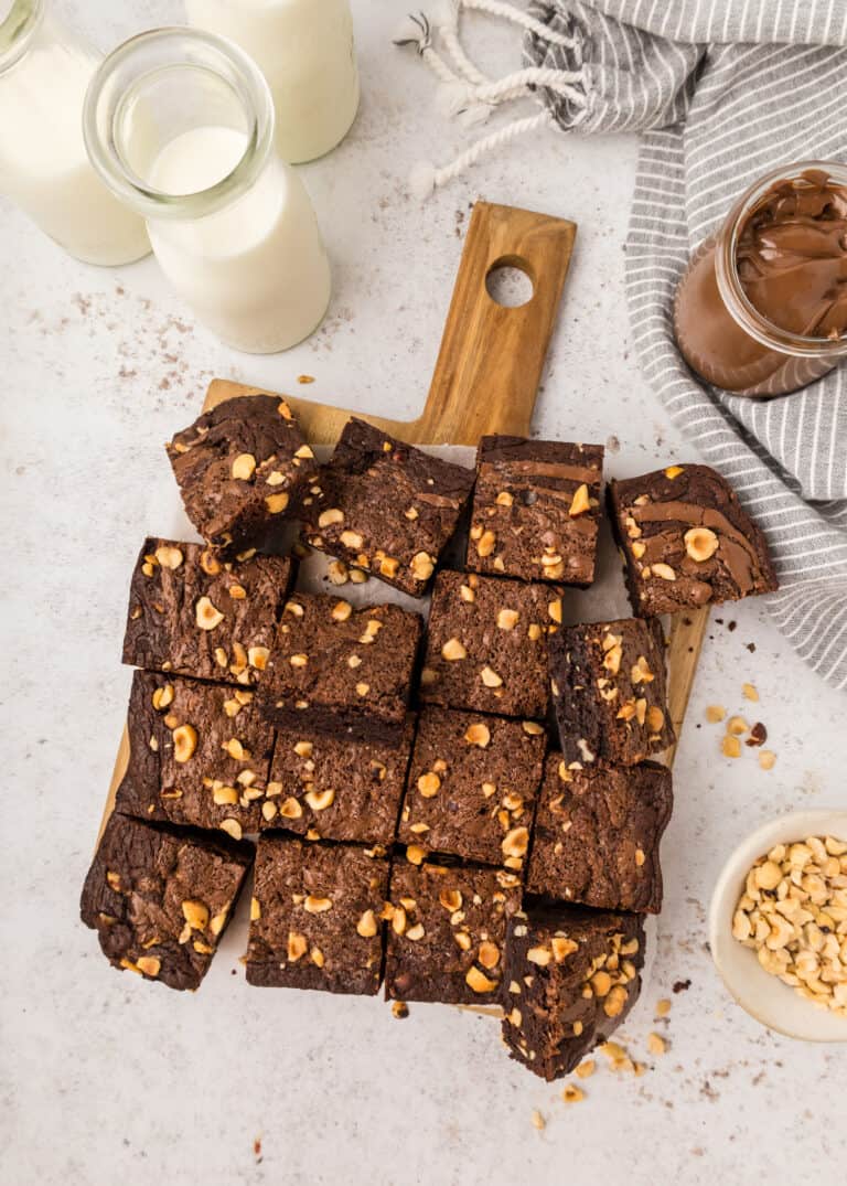 wooden cutting board with cut up pieces of Nutella brownies.