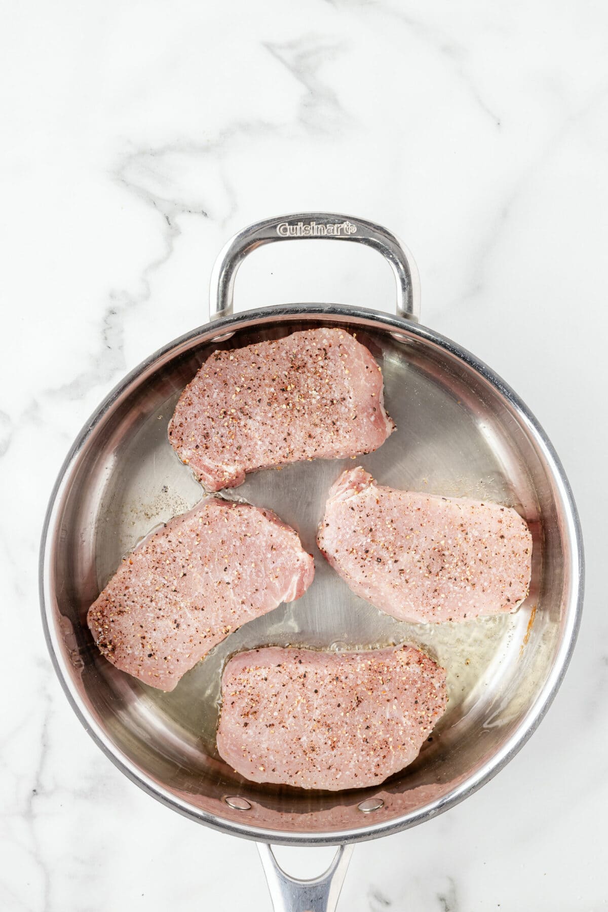 skillet with raw pork chops prior to cooking. 