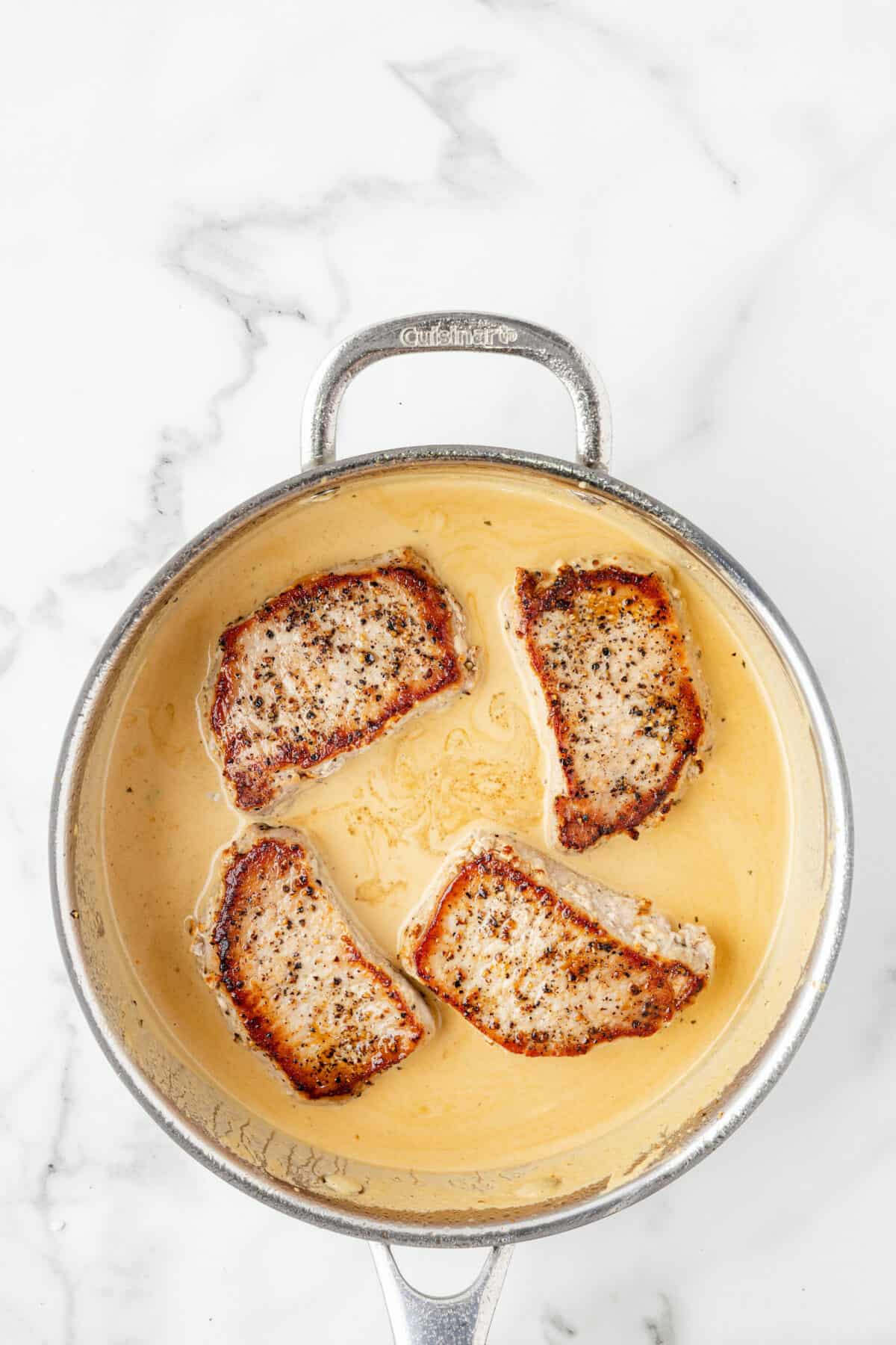 pork chops added back to the skillet with the creamy sauce. 