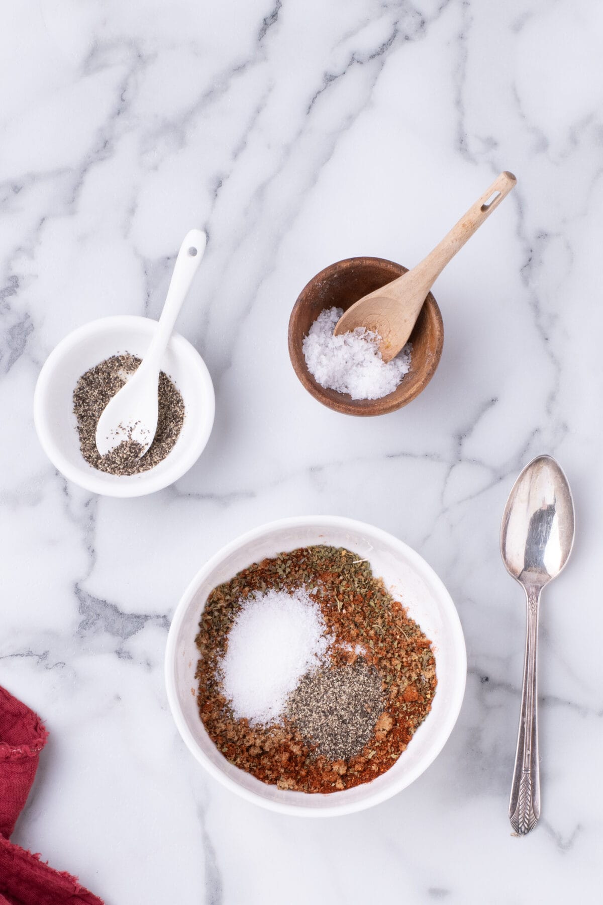 seasonings in small bowls with little spoons resting inside. 