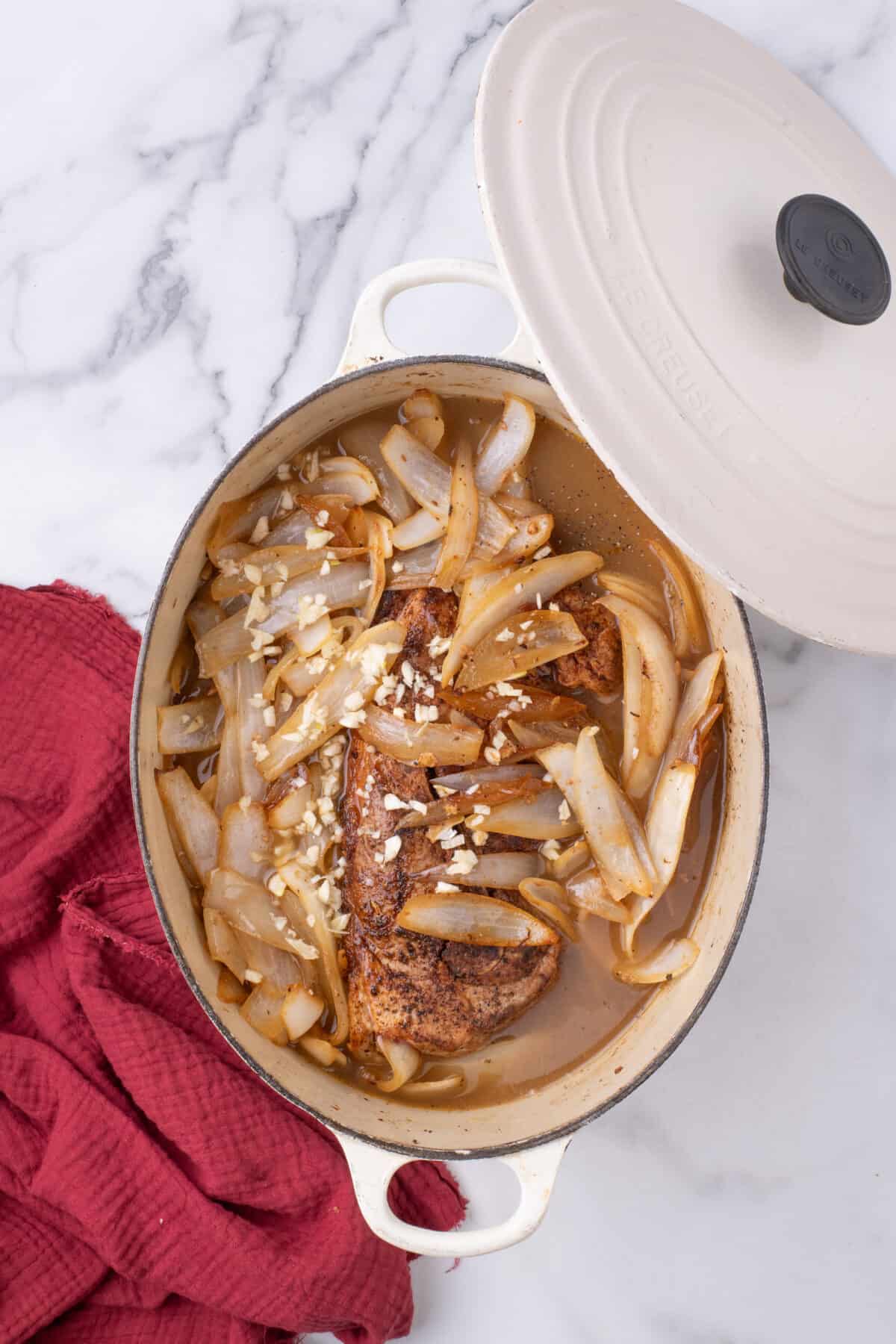 sautéed onions and minced garlic over top of pork shoulder roast in a dutch oven. 